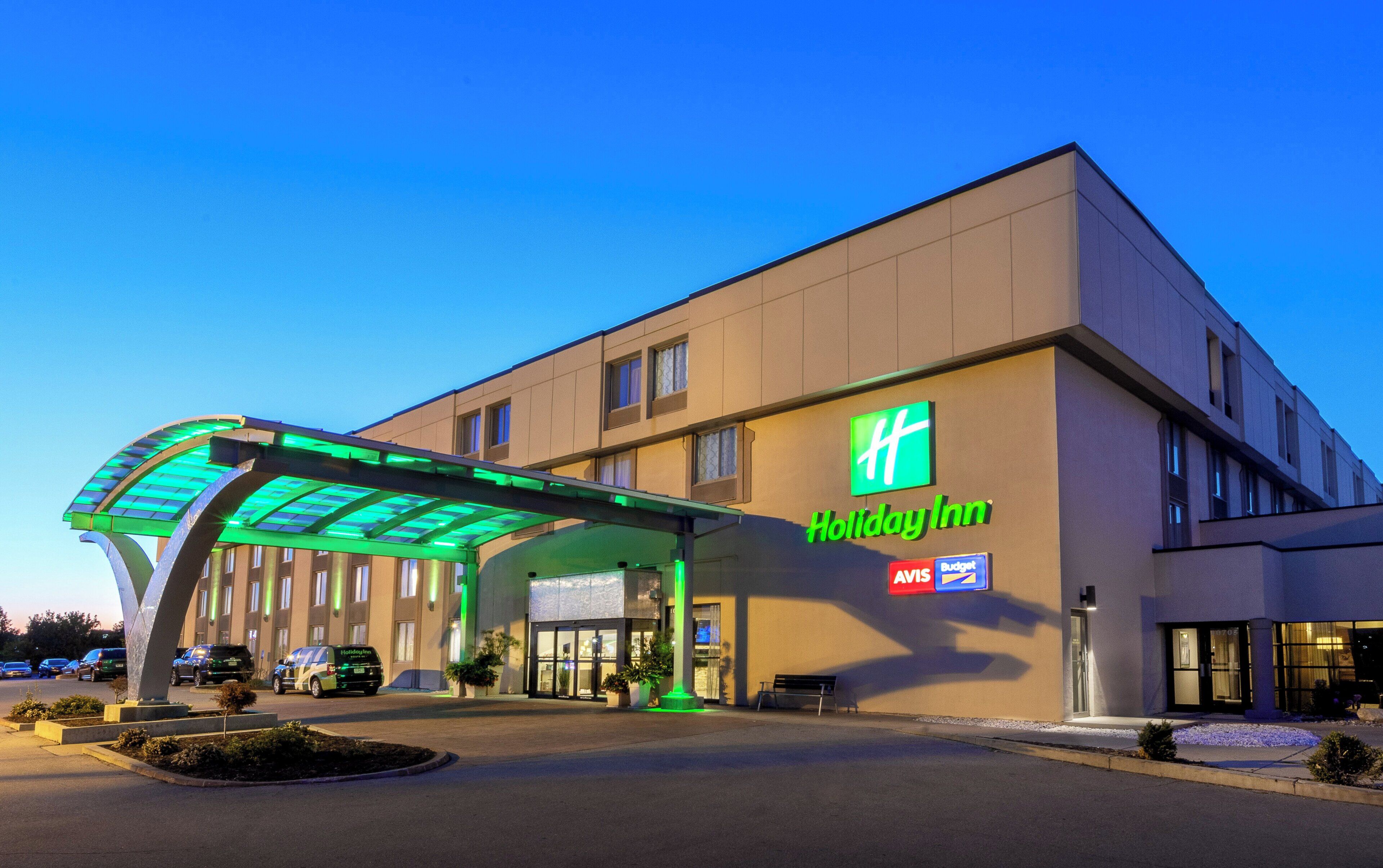 A Holiday Inn hotel with a covered walkway and a parking lot.