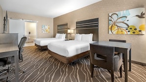 A hotel room with two beds, a desk, a chair, a lamp, and a painting on the wall. - Best Western Plus Park Place Inn - Mini Suites (Anaheim)