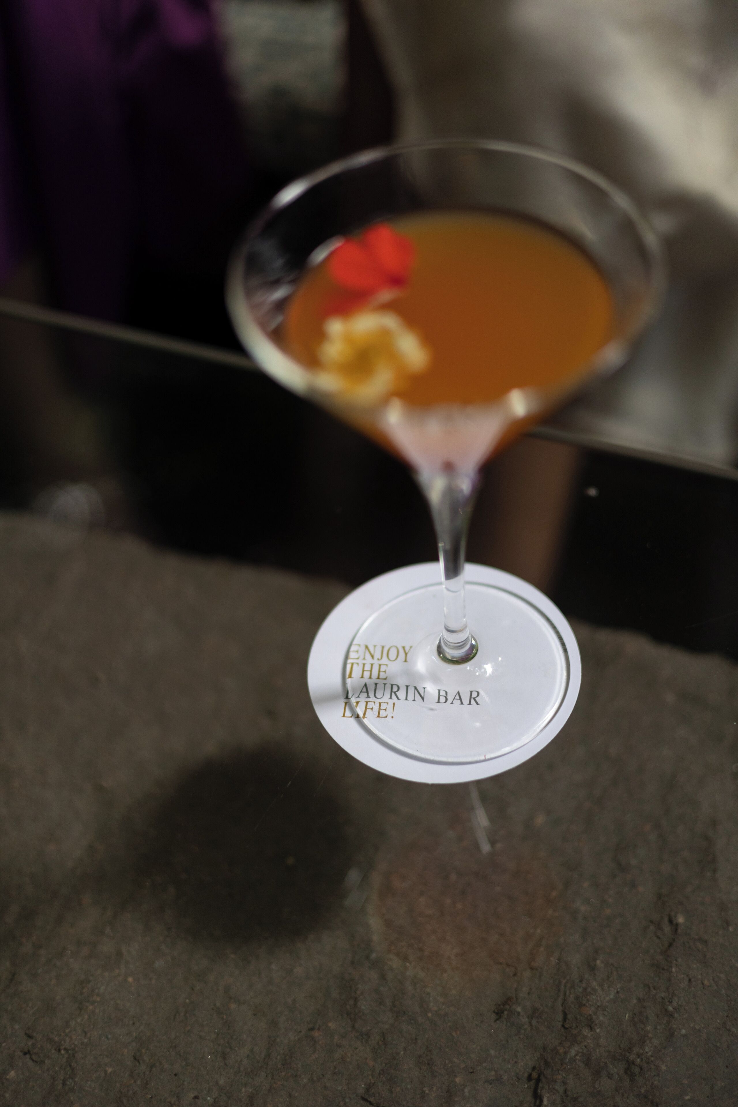 A martini glass with a garnish on a table.