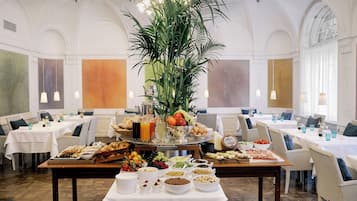 Un área de comedor con barra de buffet, que incluye diferentes tipos de comida y una planta en el centro.