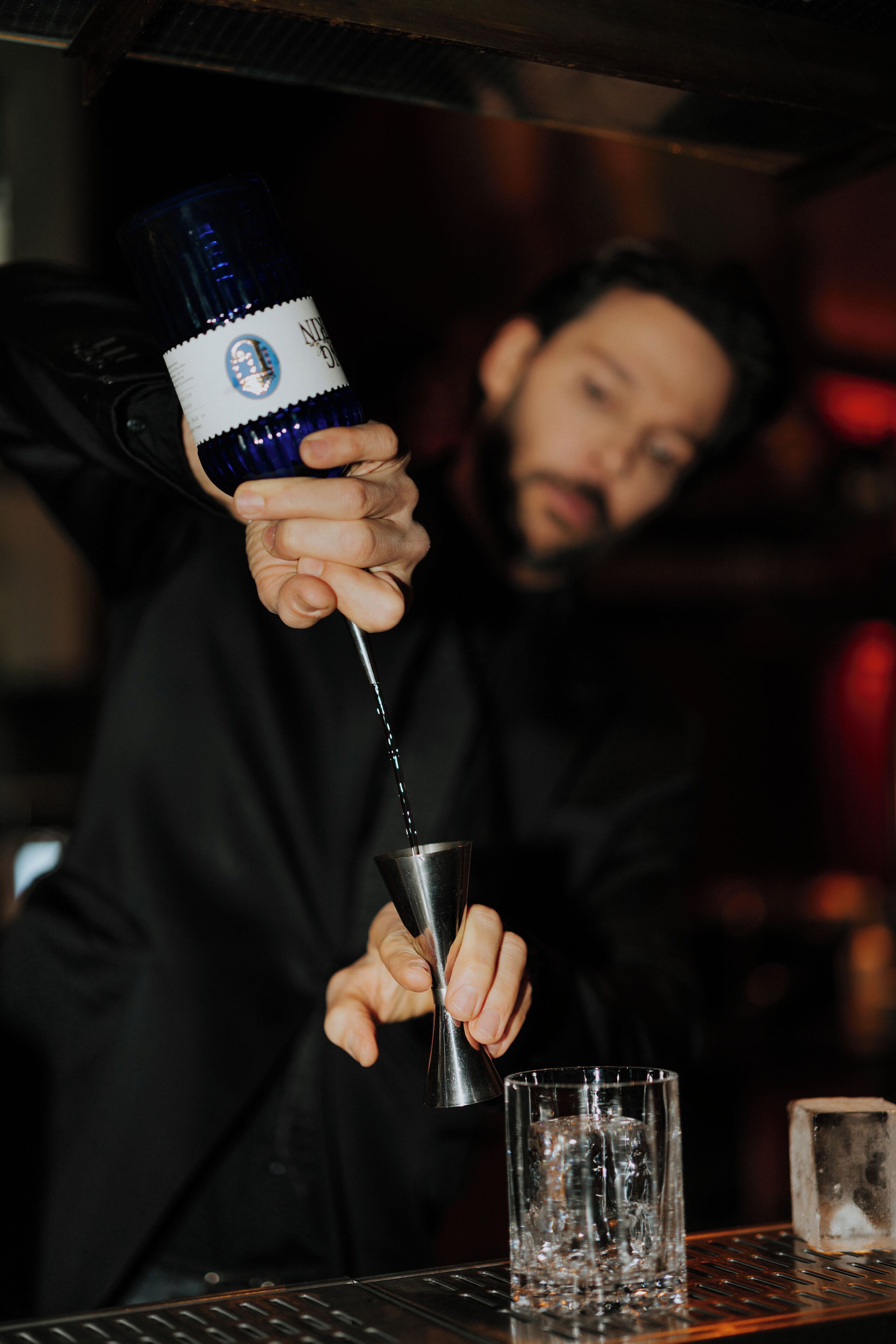 Une personne qui verse une boisson d’une bouteille dans un verre.