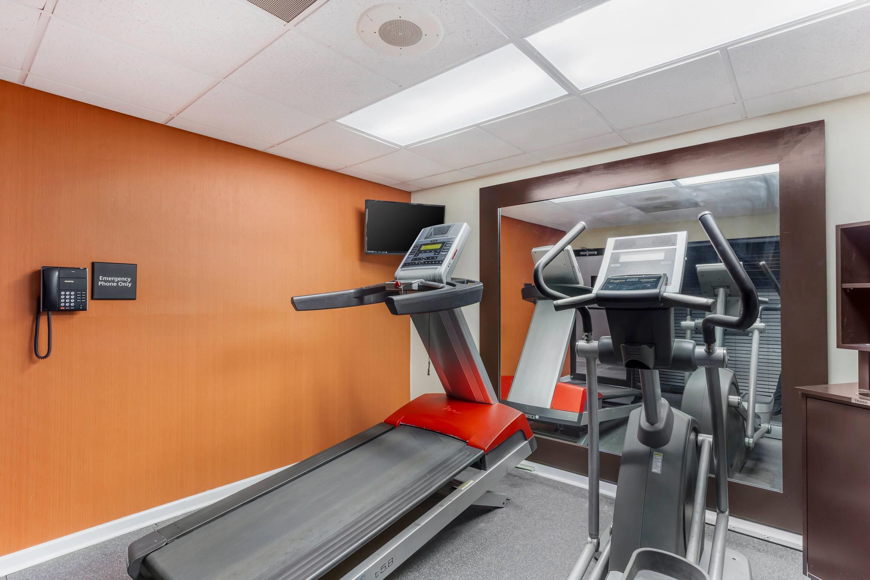 A fitness center with a treadmill, elliptical, and stationary bike.