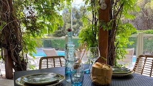 A table set outdoors with plates, glasses, and a bottle. - ibis Nimes Ouest (Nîmes)