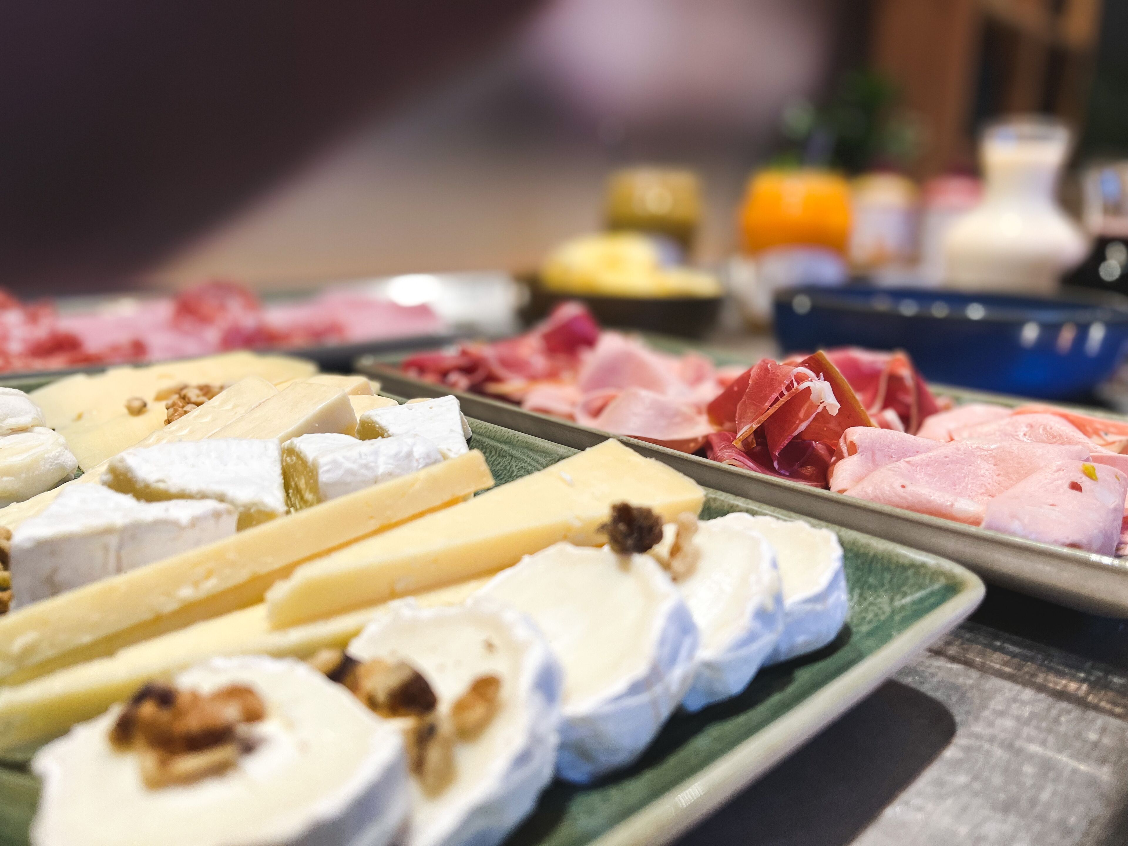 A variety of cheeses and cured meats on a tray.