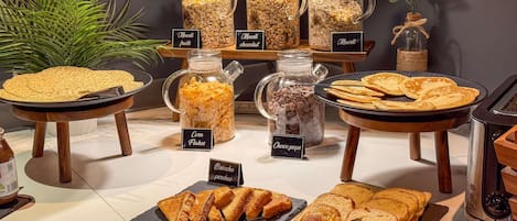 A buffet with various food items including corn flakes, chocolate, and fruit.