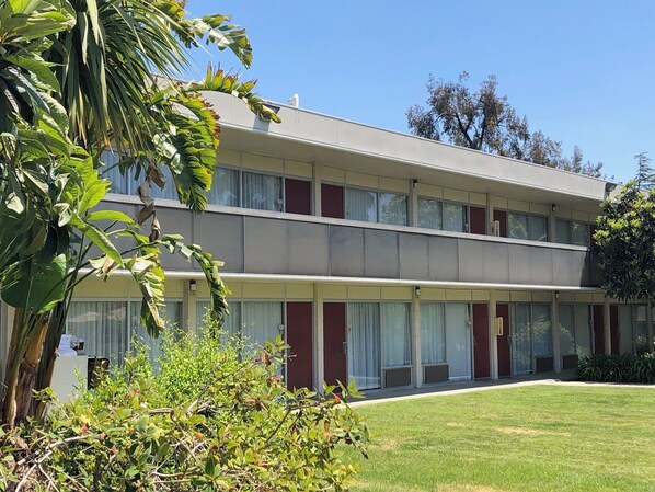 Un edificio de dos plantas con techo plano, ventanas grandes y un césped cuidado.