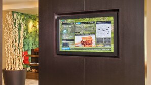 A digital display in a lobby with a news feed, weather information, and a map. - Courtyard by Marriott Mt. Laurel (Mount Laurel)