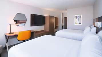 A hotel room with two beds, a desk with a chair, a TV, and a framed picture on the wall.