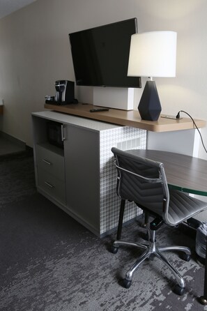 A hotel room with a desk, a chair, a television, and a lamp. - Holiday Inn & Suites Chicago North Shore (Skokie) by IHG (Skokie)