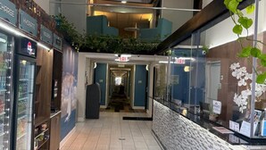 A hotel corridor with a vending machine, a reception desk, and a staircase leading to an upper level. - Wingate by Wyndham Columbia/Fort Jackson (Columbia)