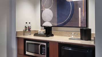 Cocina compacta equipada con microondas, cafetera y lavavajillas.