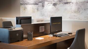 Een receptiebalie met een printer, een computer en een bord met daarop Marriott Bonvoy.