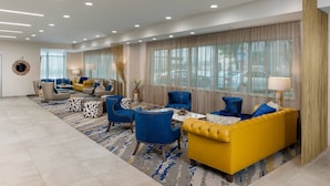A modern living room with a yellow sofa, blue armchairs, and a patterned rug. - Fairfield Inn & Suites Fort Worth Downtown/Convention Center (Fort Worth)