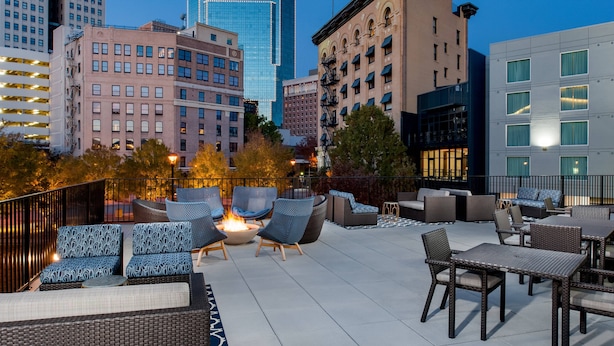 An outdoor patio with wicker furniture, a fire pit, and city views. - Fairfield Inn & Suites Fort Worth Downtown/Convention Center (Fort Worth)