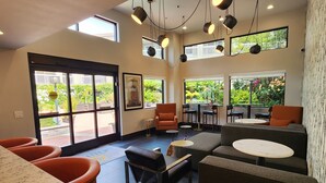 Un interior moderno con zona de estar, bar y amplios ventanales con vistas al exterior.