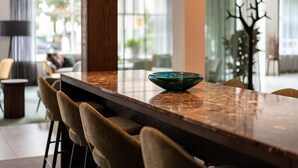 Un espace repas moderne avec une table en bois, des tabourets de bar et un vase décoratif en verre.