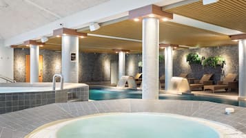 Ett spaområde med ett bubbelbad, en liten pool och solstolar.