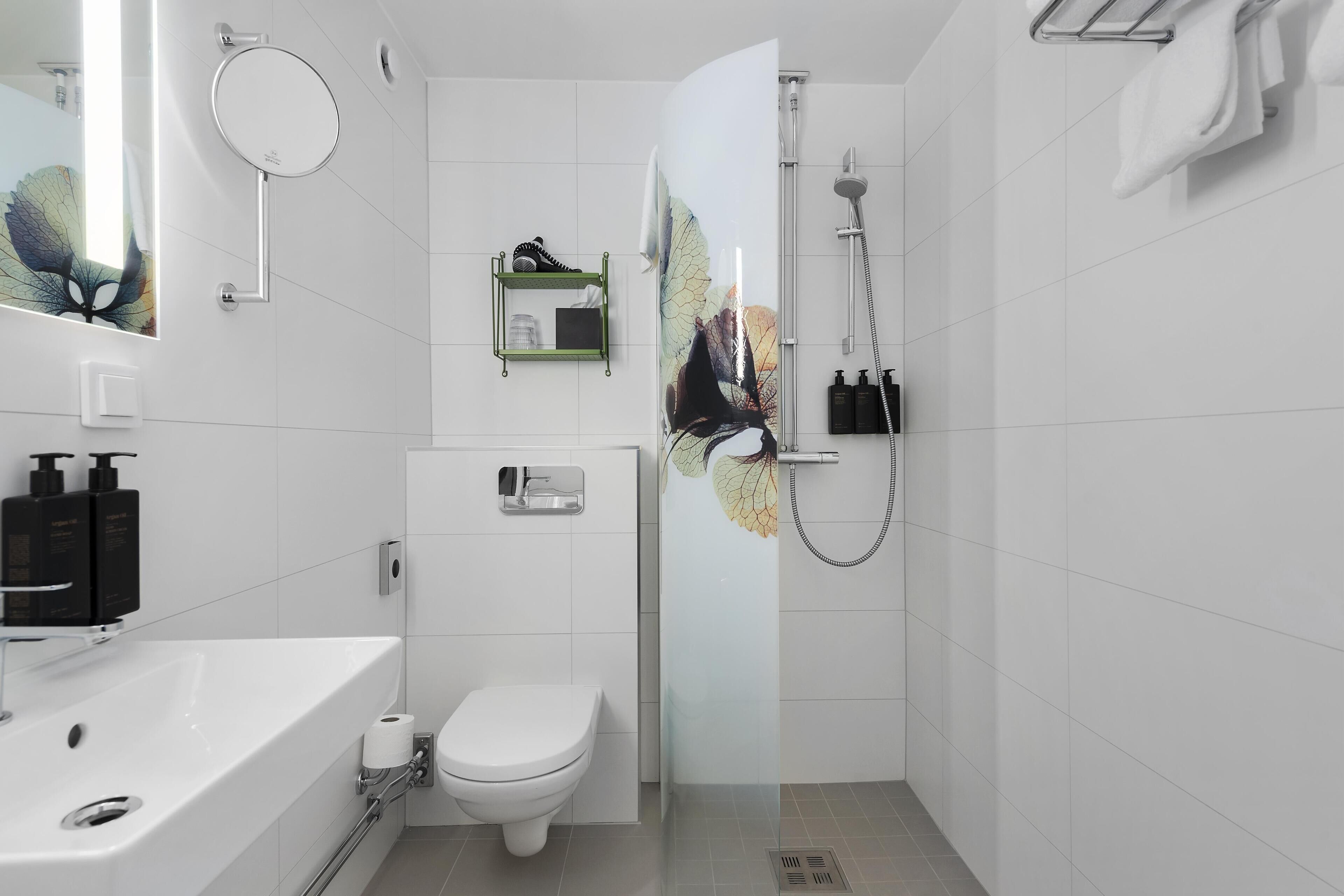 A modern bathroom with a white sink, toilet, and shower.
