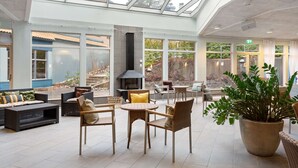 Un vaste espace intérieur doté d’un haut plafond, de grandes fenêtres et d’une cheminée.