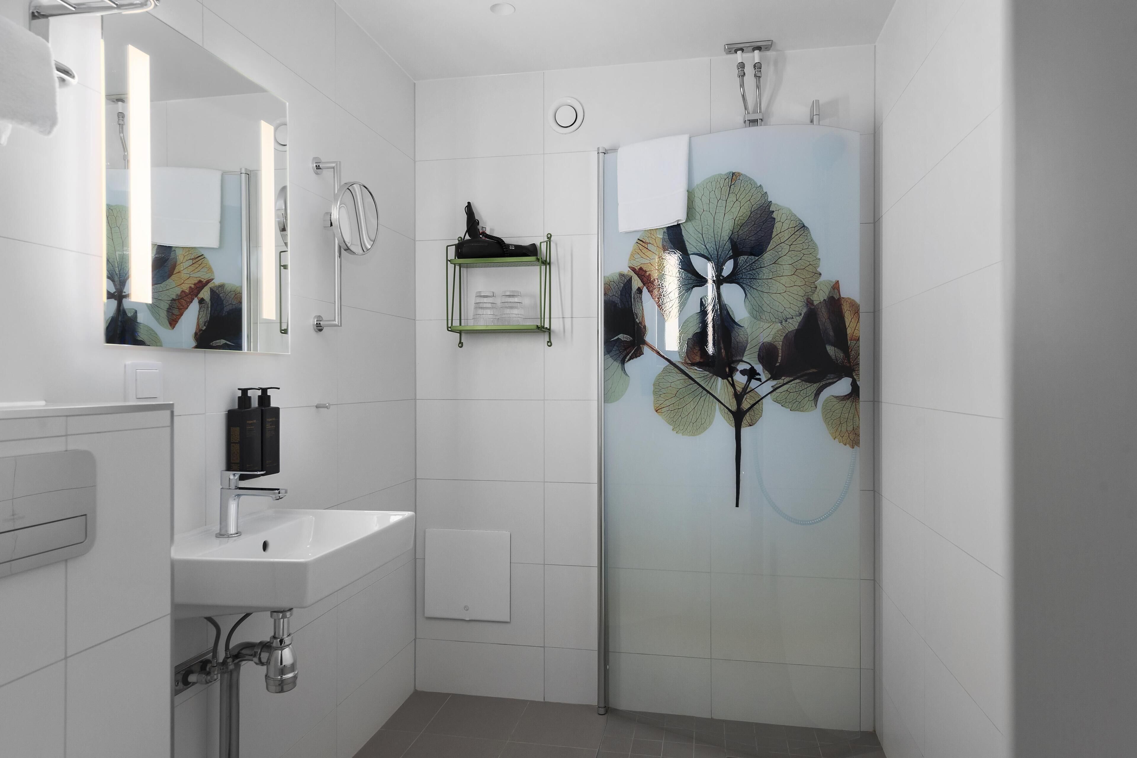 Ein modernes Badezimmer mit Waschbecken, Spiegel und Dusche.