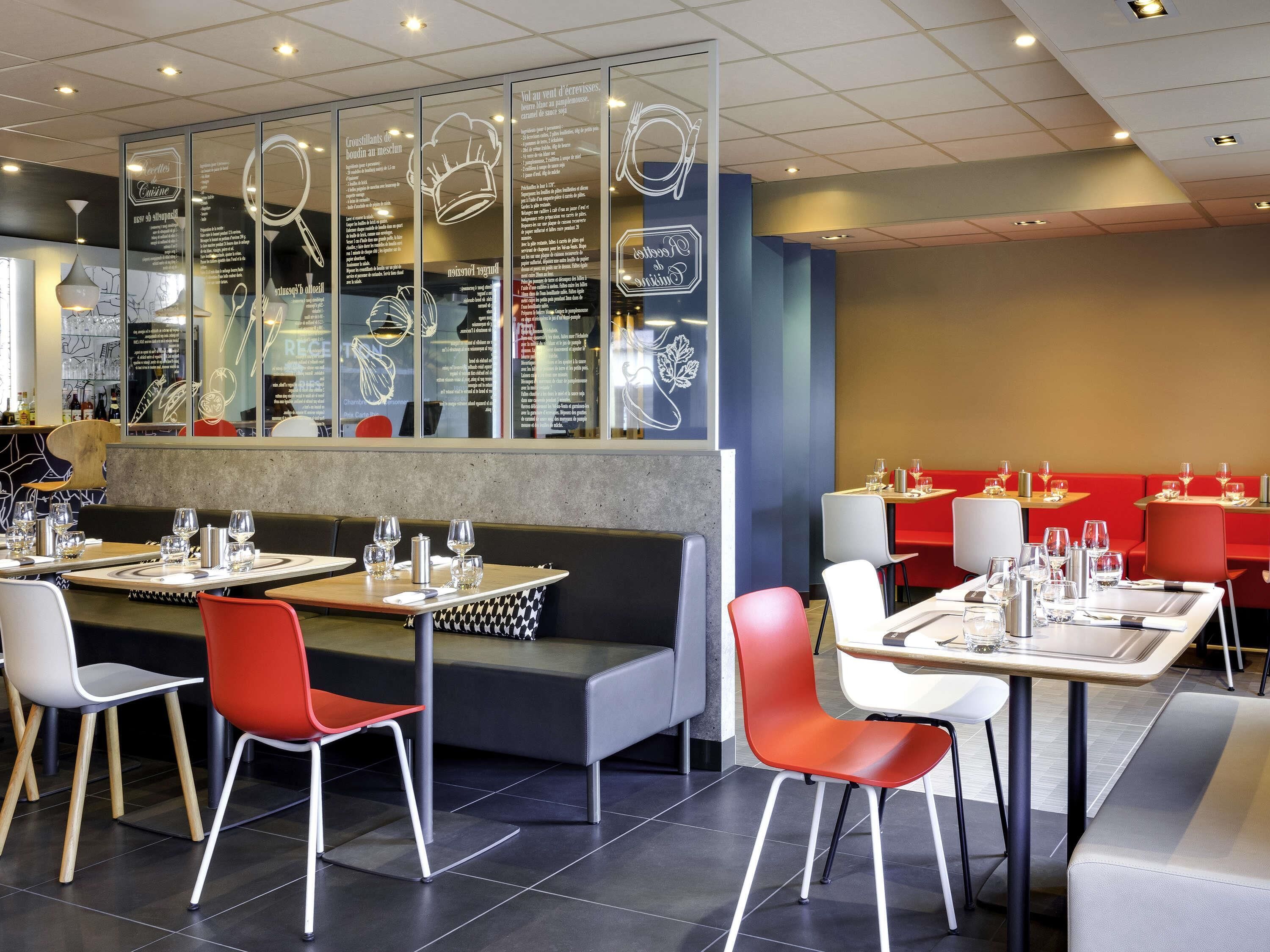 L'intérieur d'un restaurant, avec des tables, des chaises et un présentoir à menus.