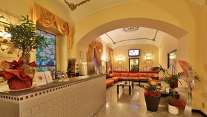 A hotel lobby with a reception desk, a sofa, and potted plants. - Best Western Hotel Genio (Turin)