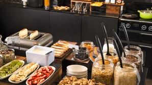 A buffet with various food items, including sliced fruits, bread, and cereal. - Mercure Nancy Centre Place Stanislas Hotel (Nancy)