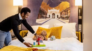A hotel room with a bed, pillows, a teddy bear, and a toy train. - Mercure Nancy Centre Place Stanislas Hotel (Nancy)