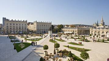 A spacious public square with a central fountain, surrounded by historic buildings and greenery.
