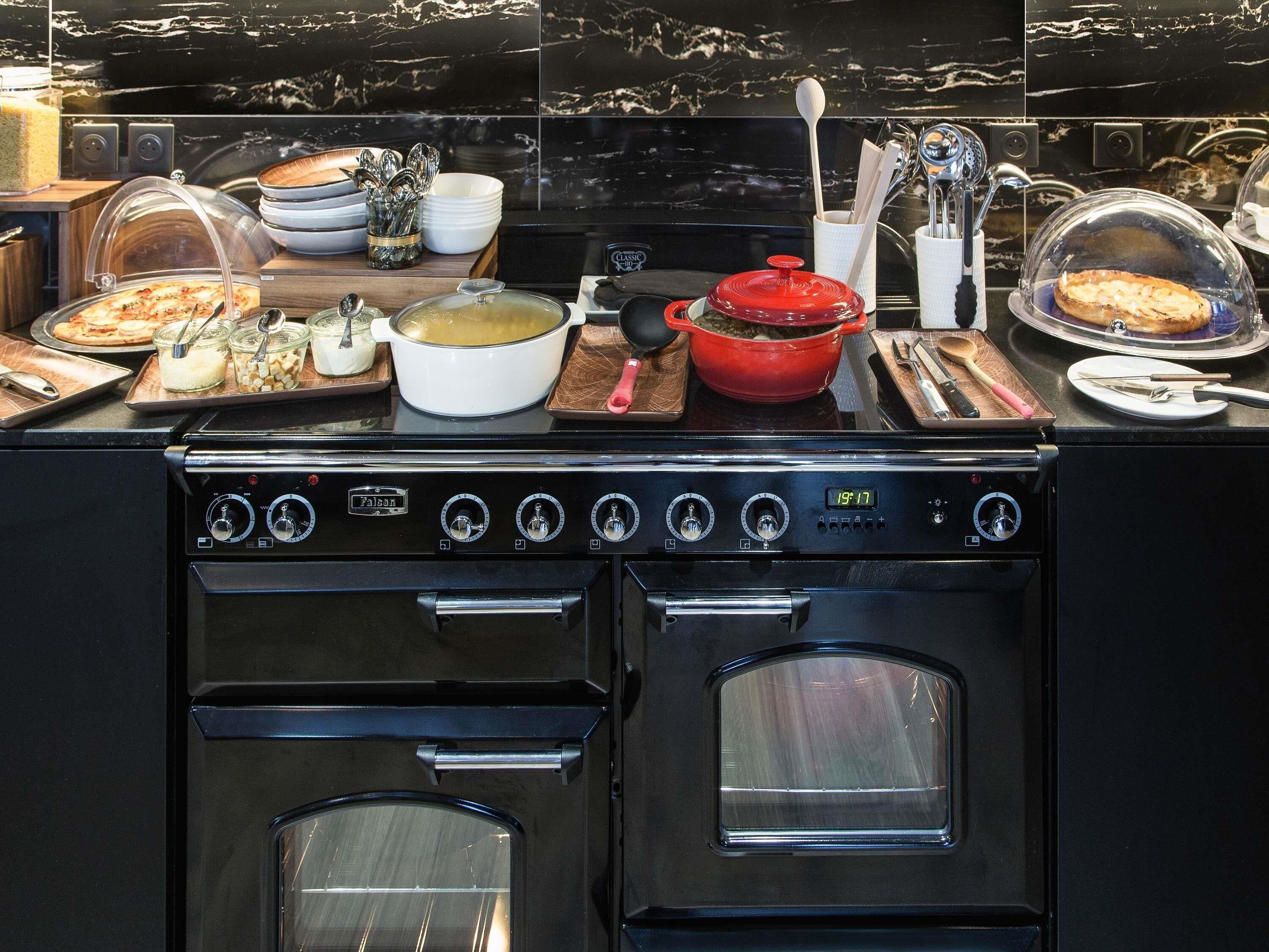 A kitchen with a stove, oven, and various food items on the counter.