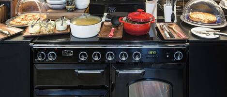 A kitchen with a stove, oven, and various food items on the counter.