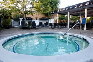 Un espace avec un bain à remous, des chaises longues et un coin salon abrité.