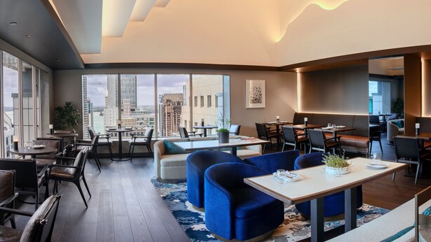 A modern hotel lobby with a high ceiling, large windows offering city views, and a mix of seating areas including sofas and tables. - Crowne Plaza Auckland by IHG (Auckland)