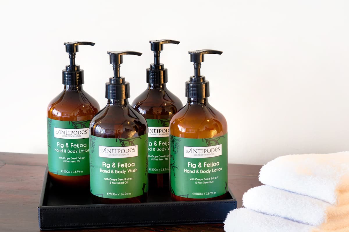 Bottles of hand and body lotion, featuring grape seed extract and kiwi seed oil, are arranged on a tray.