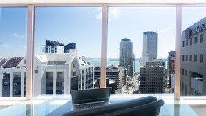A modern office with a large window overlooking a cityscape. - Crowne Plaza Auckland by IHG (Auckland)