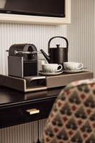 Una cafetera, dos tazas y una tetera sobre una bandeja.