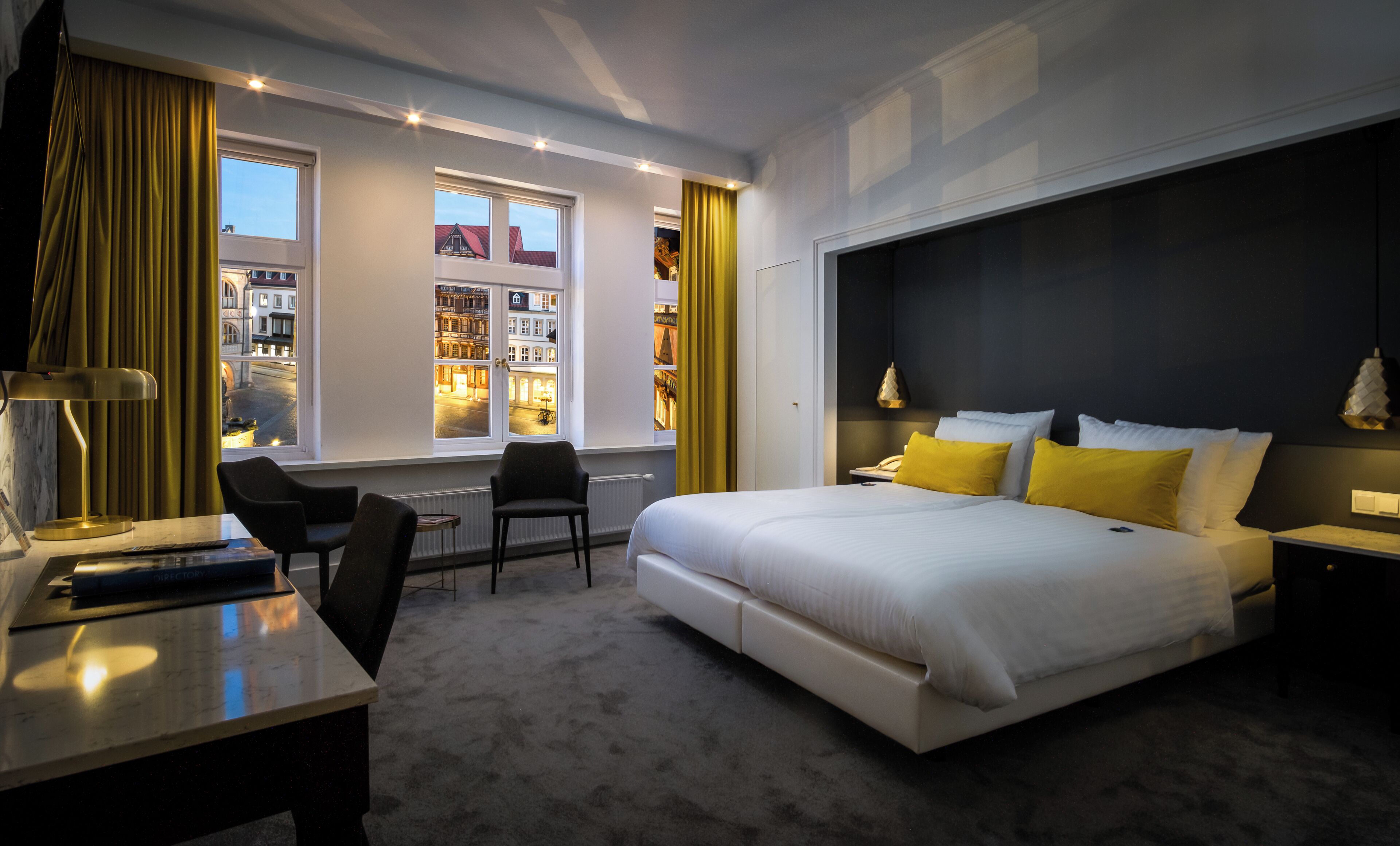 Una habitación de hotel moderna con una cama grande, un escritorio y una silla.
