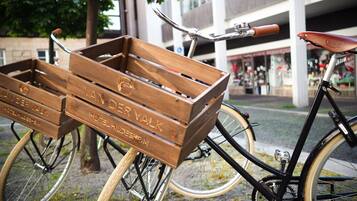 A bicycle with wooden crates attached to the front, each crate engraved with "VAN DER VALK HOTEL HILDESHEIM".