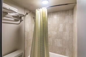 A shower with a curtain, tiled walls, and a towel rack. - Rodeway Inn Arlington Entertainment District Area (Arlington)