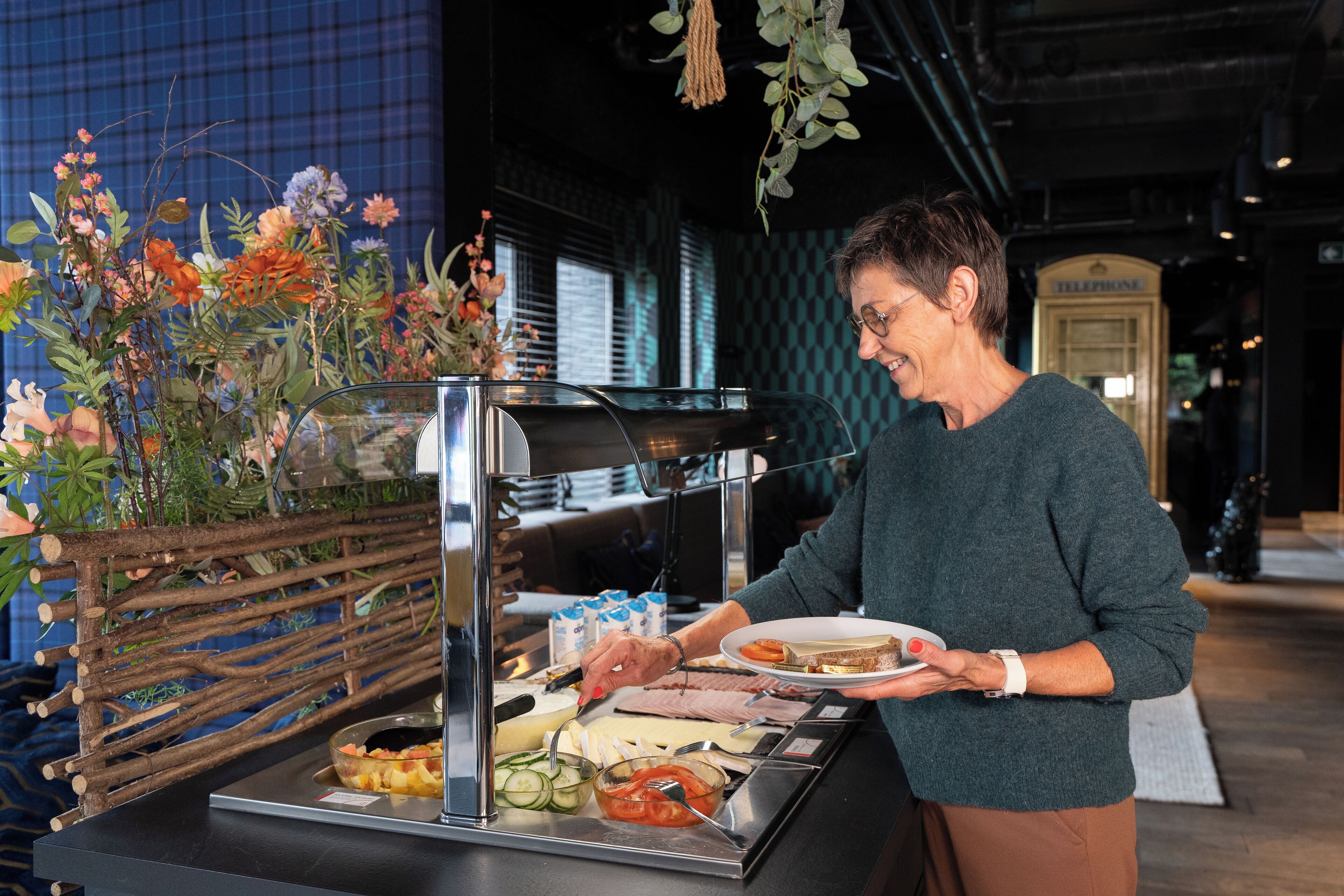 Een buffetopstelling met diverse gerechten en een decoratieve plantenarrangement.
