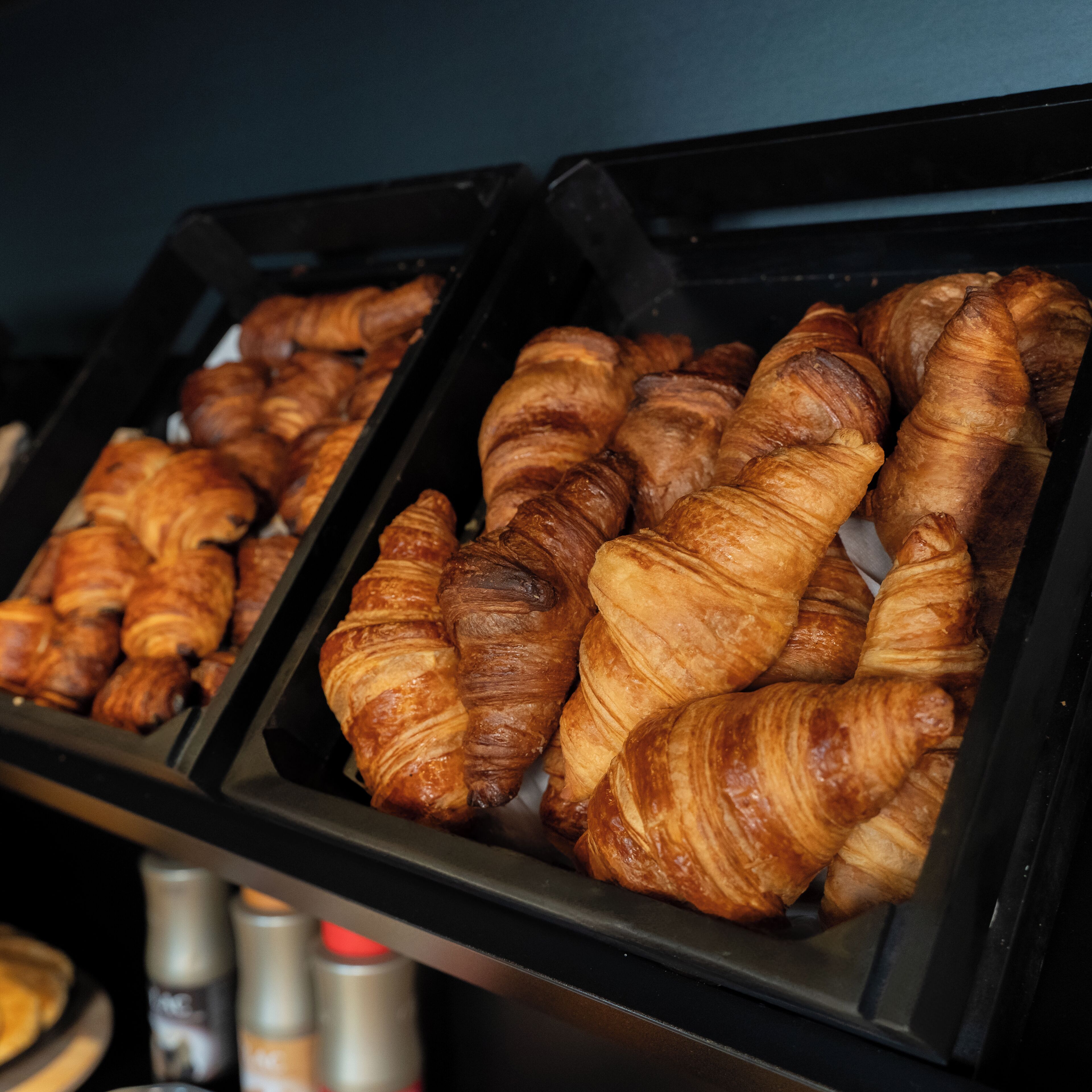 Une vitrine remplie de croissants fraîchement sortis du four, dans une boulangerie.