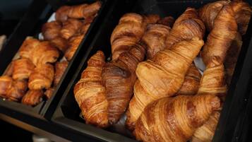 Une vitrine remplie de croissants fraîchement sortis du four, dans une boulangerie.