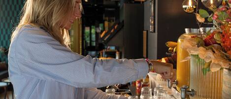 A person serving themselves cereal from a buffet.