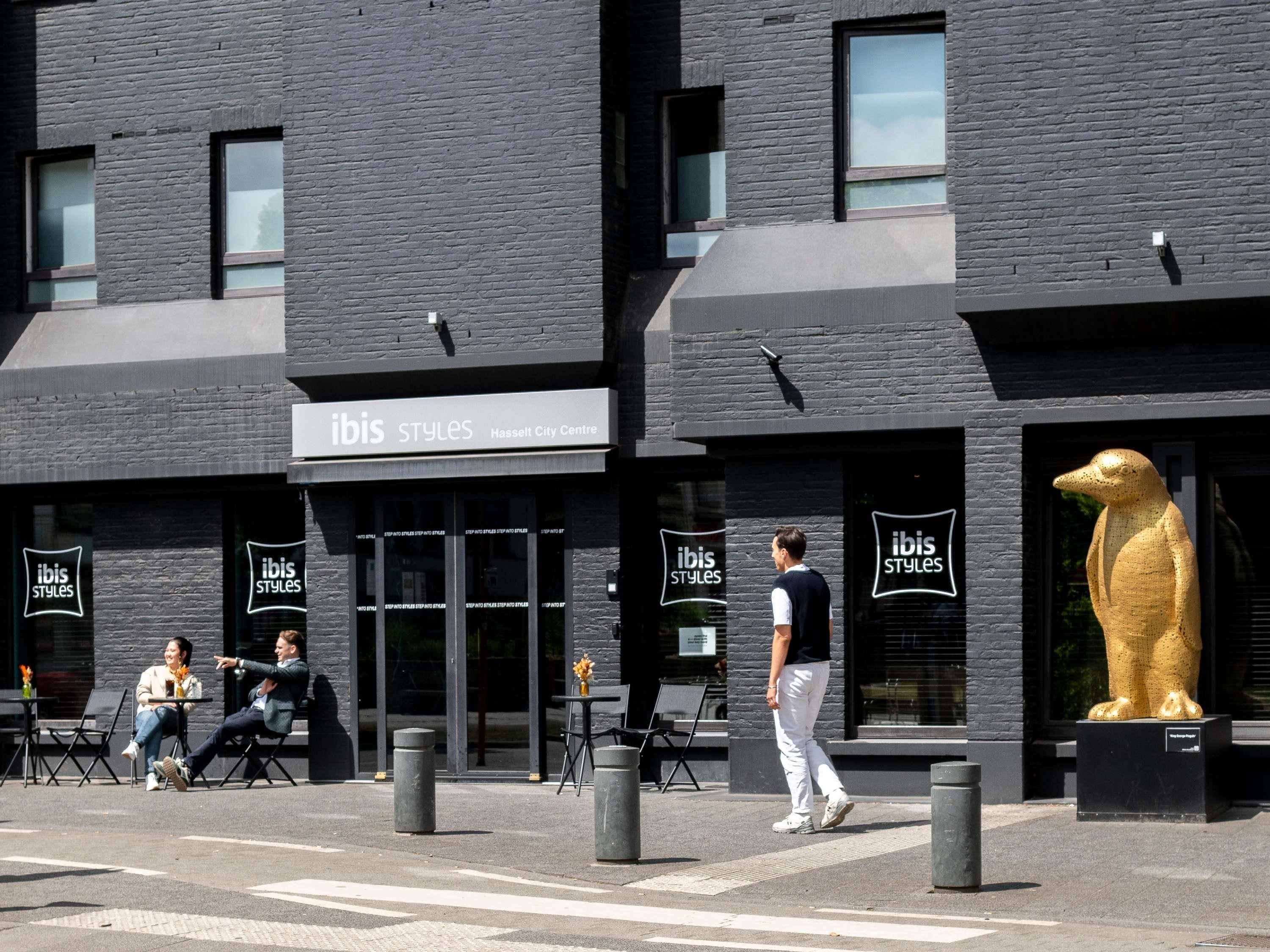 A modern building with a sign for 'ibis Styles' at Hasselt City Centre.