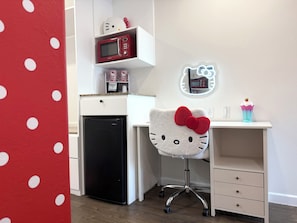 A compact kitchenette with a microwave, refrigerator, and a Hello Kitty-themed chair. - The Dixie Hollywood (Los Angeles)