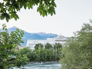 A river with a building in the background and mountains in the distance.
