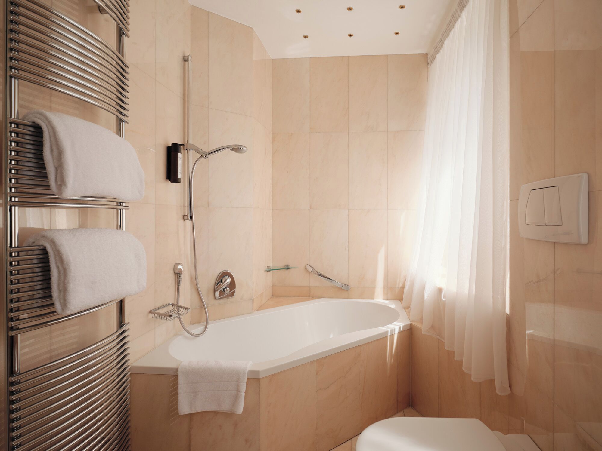 A modern bathroom with a bathtub, a shower, and a toilet.