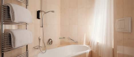 A modern bathroom with a bathtub, a shower, and a toilet.