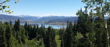 A mountainous landscape with dense forests and a lake.