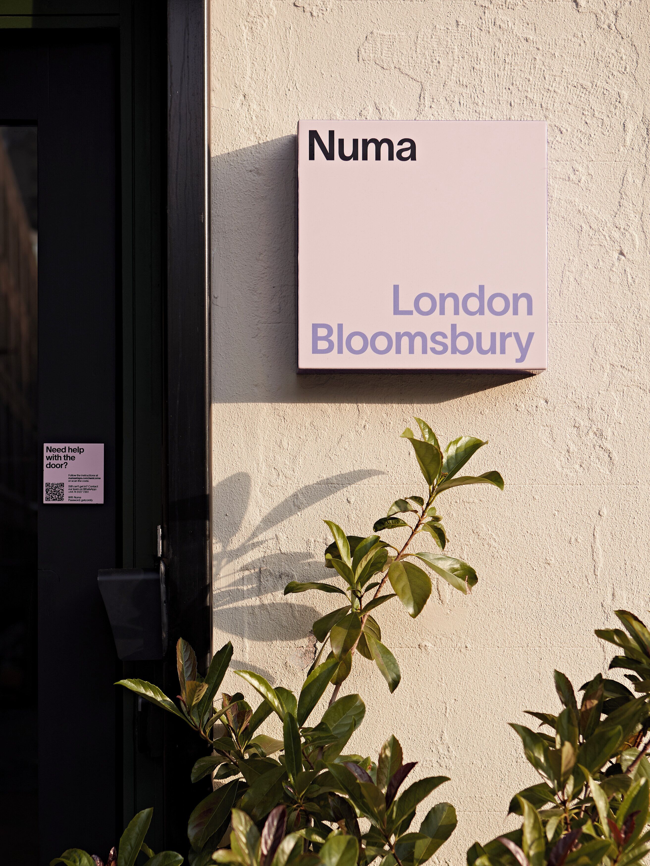 A sign with 'Numa London Bloomsbury' on a building wall.